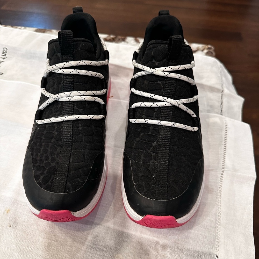 Nurture black with pink tennis shoes.